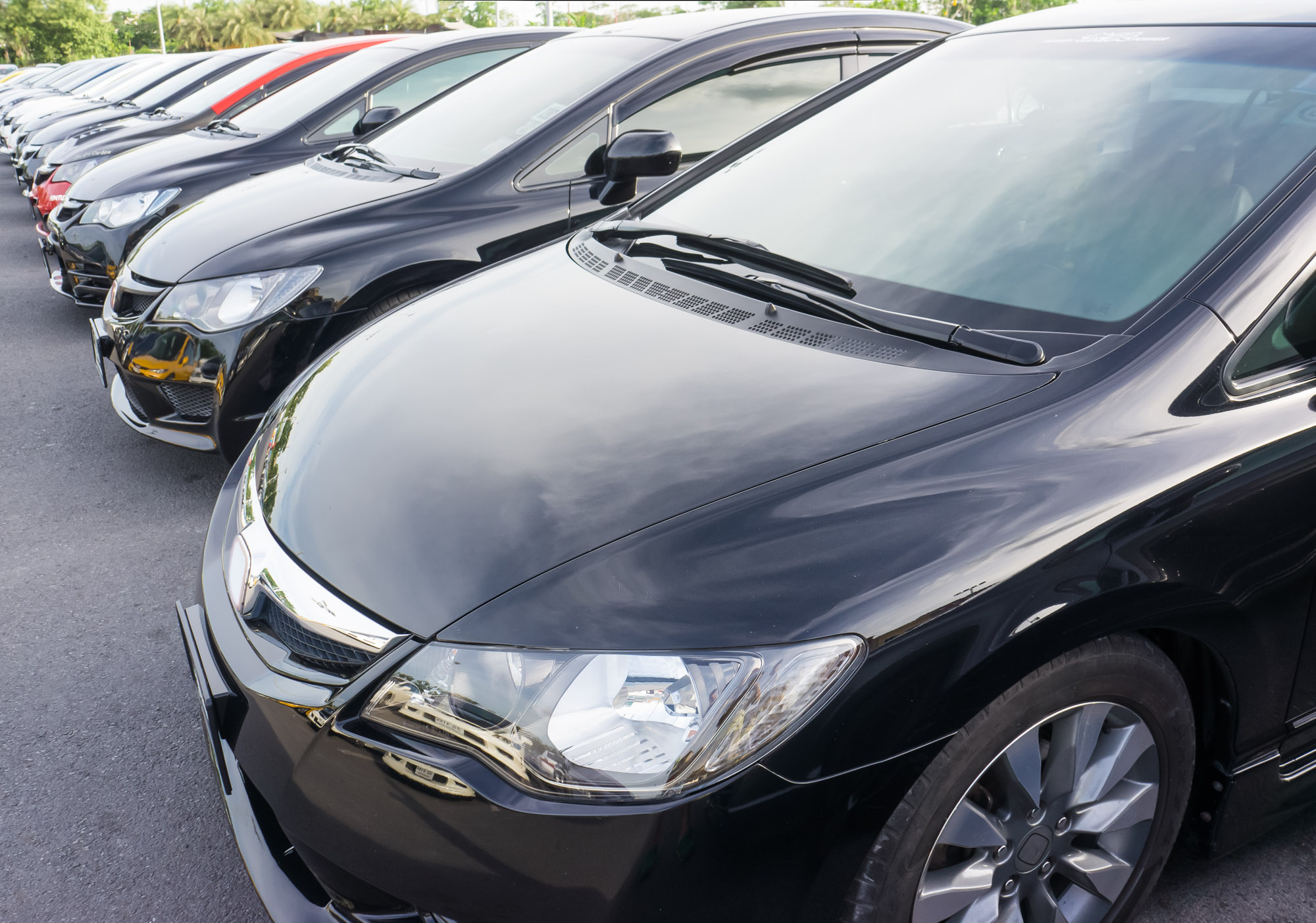 Row of black cars parked in lot