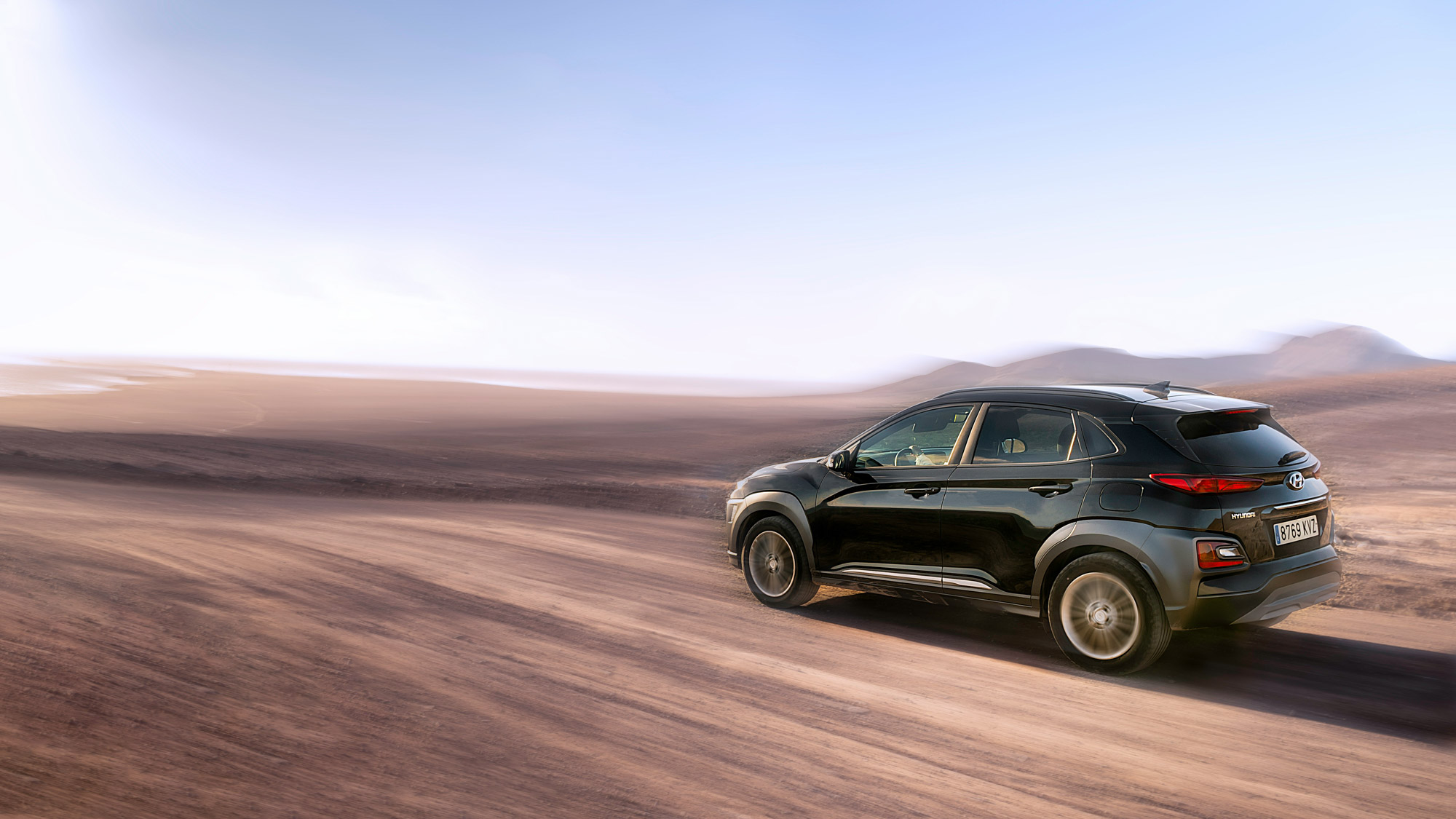 Black SUV driving on desert dirt road