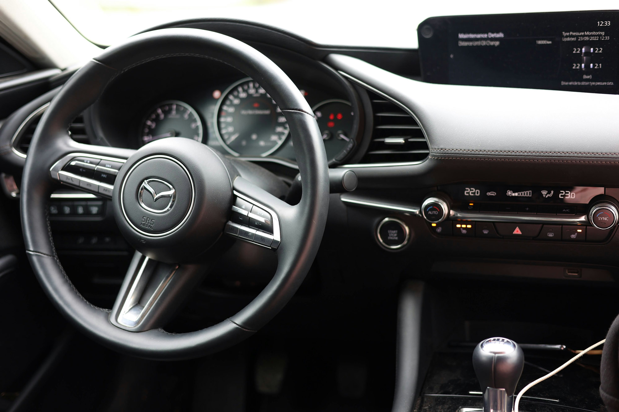 Modern Mazda car interior with steering wheel and dashboard