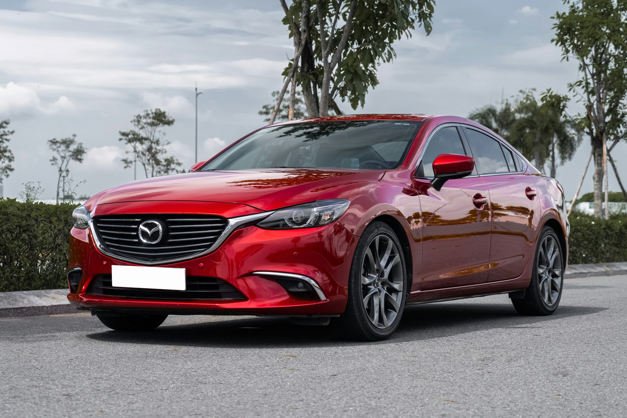 Red Mazda sedan parked on city street