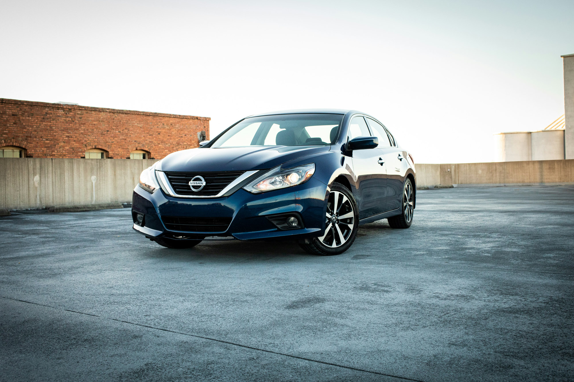 Blue Nissan sedan on rooftop parking garage